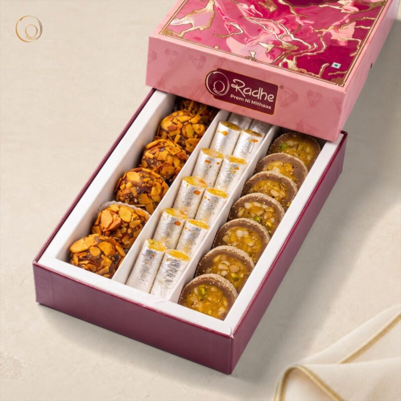 Royal Kaju Gift Box 500g Royal Kaju Gift Box 500g – silver-varakh Kaju Kesar Rolls, Anjeer Chakra slices and almond-coated dry fruit balls in a pink Radhe gift box